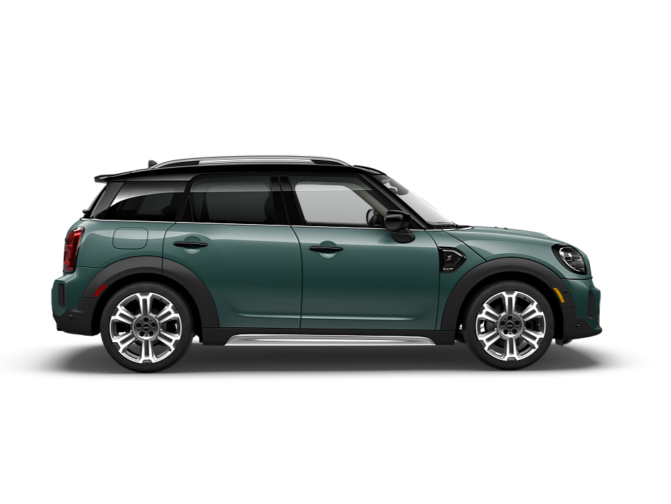 Side view of a dark green MINI Countryman parked on a blank surface with nothing in the background.